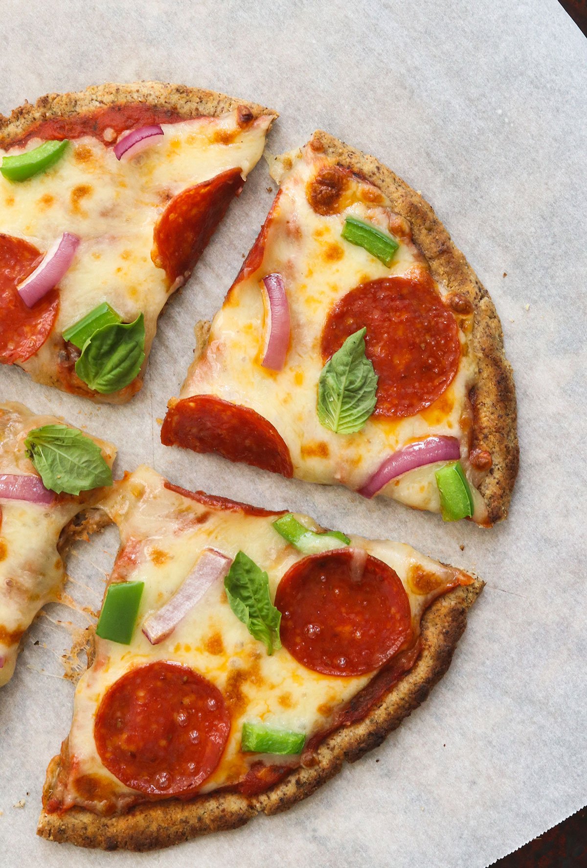 almond flour pizza sliced into quarters and topped with pepperoni.