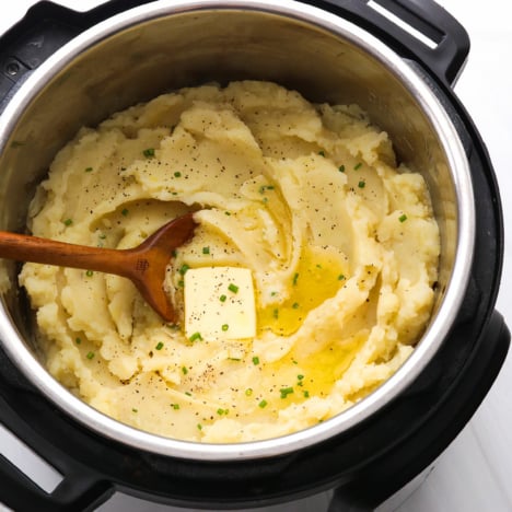 Mashed Potatoes topped with butter and chives in the Instant Pot.