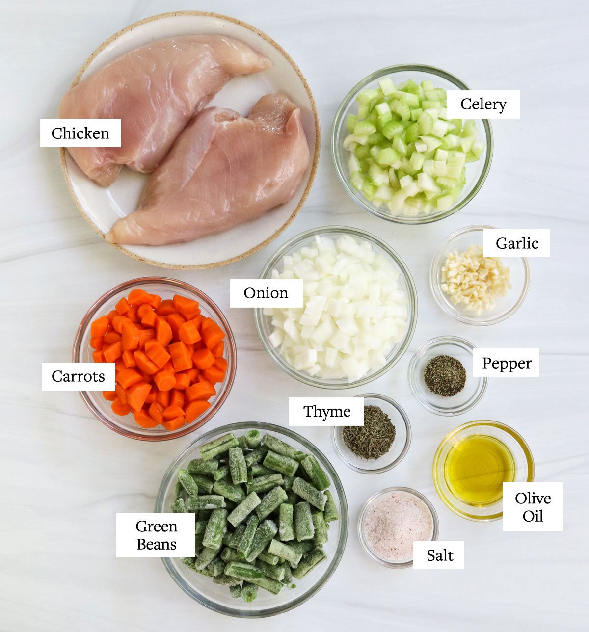 chicken veggie soup ingredients labled on white surface.