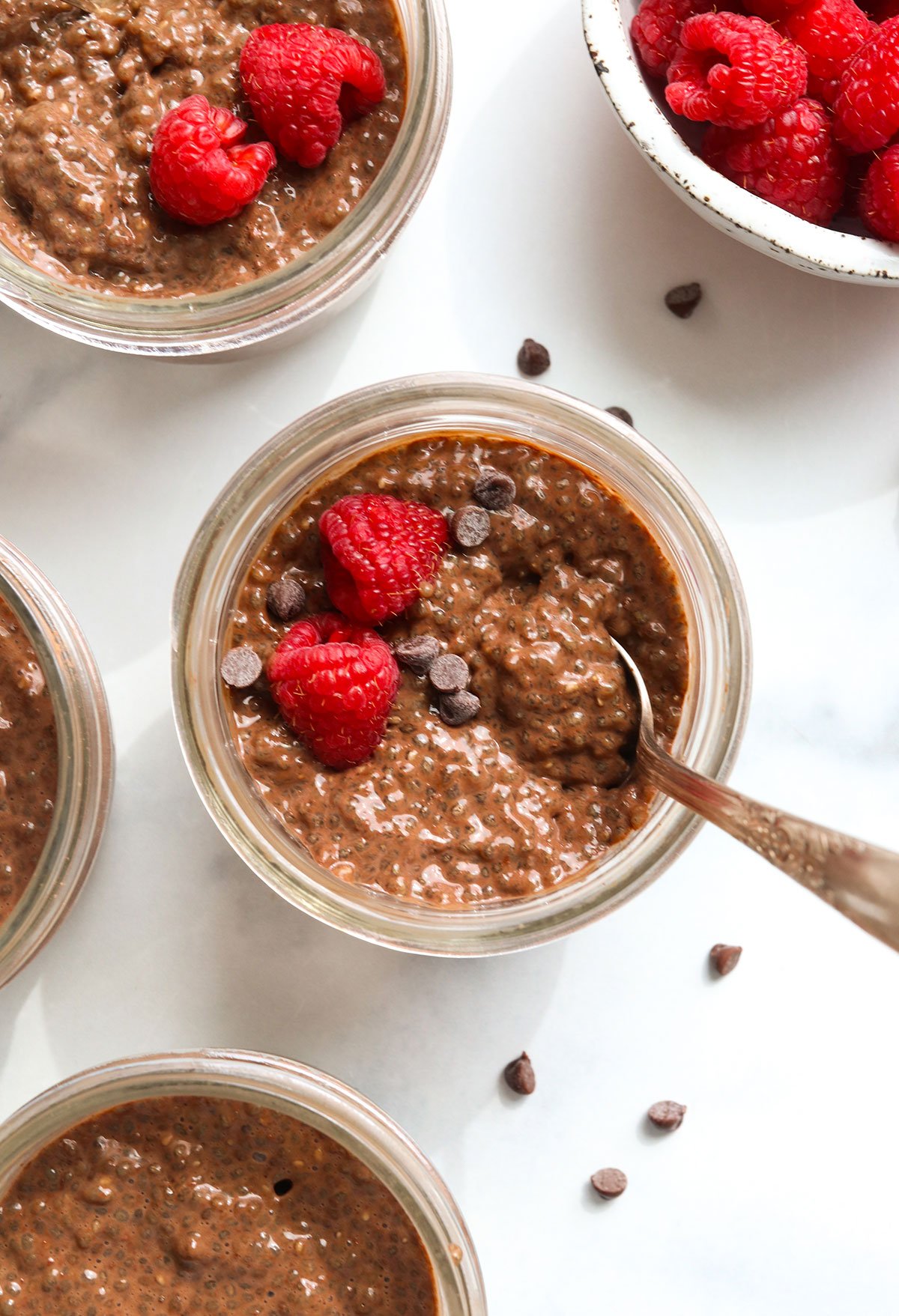 chocolate chia pudding topped with raspberries and chocolate chips.