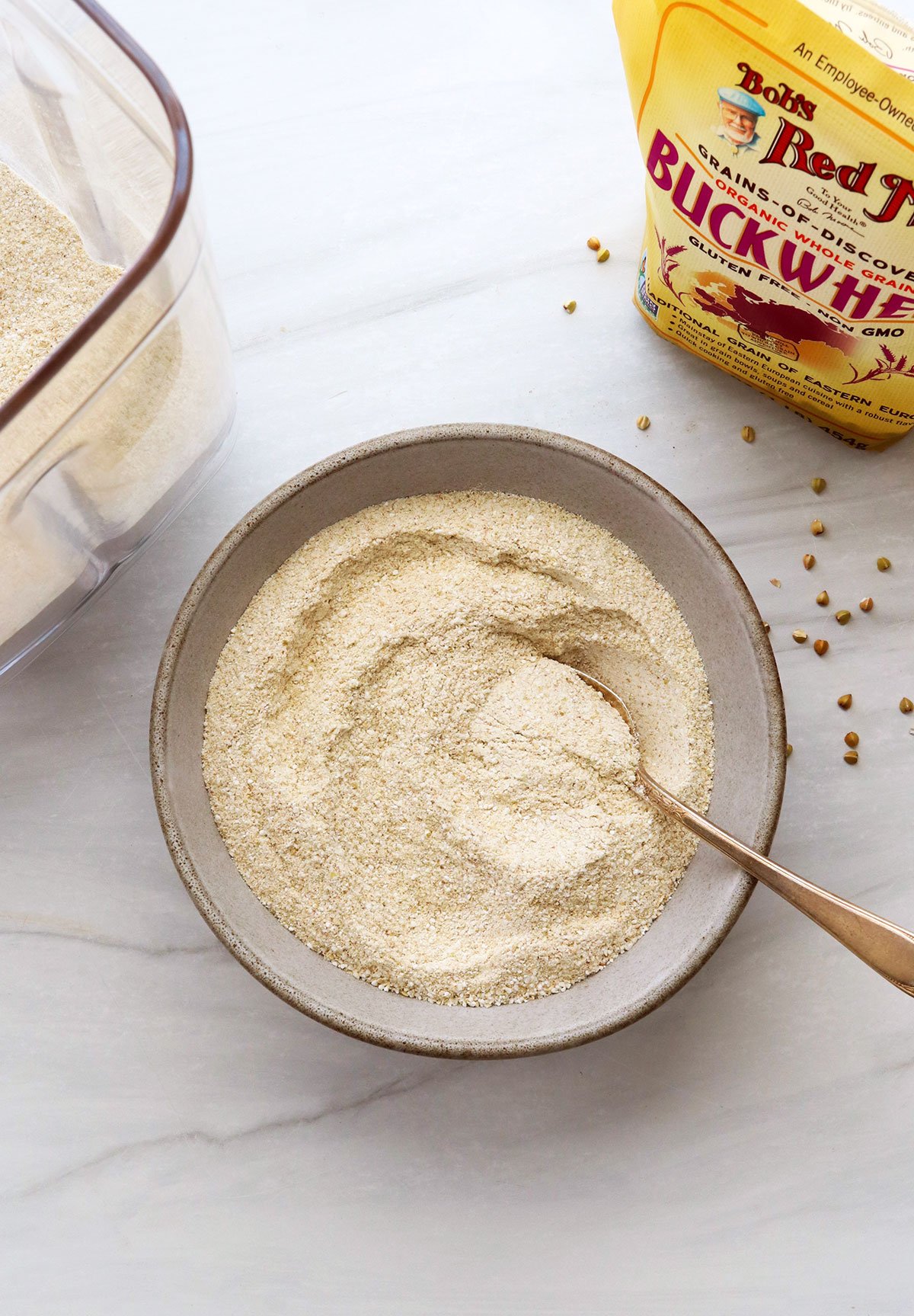 Homemade buckwheat flour in a bowl with a spoon.