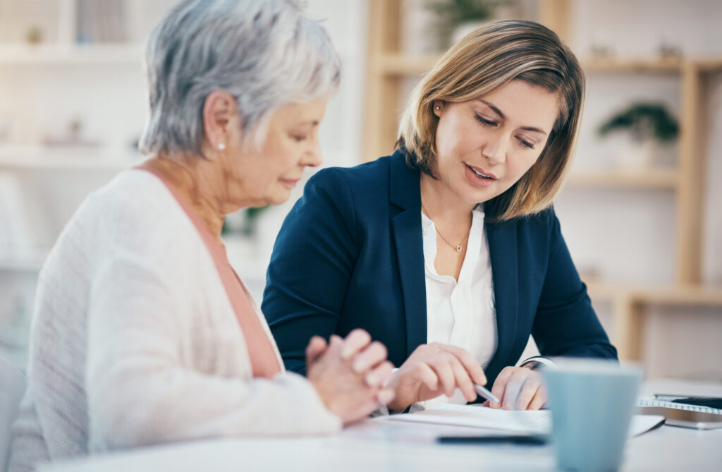 elderly woman reviewing paperwork with a woman