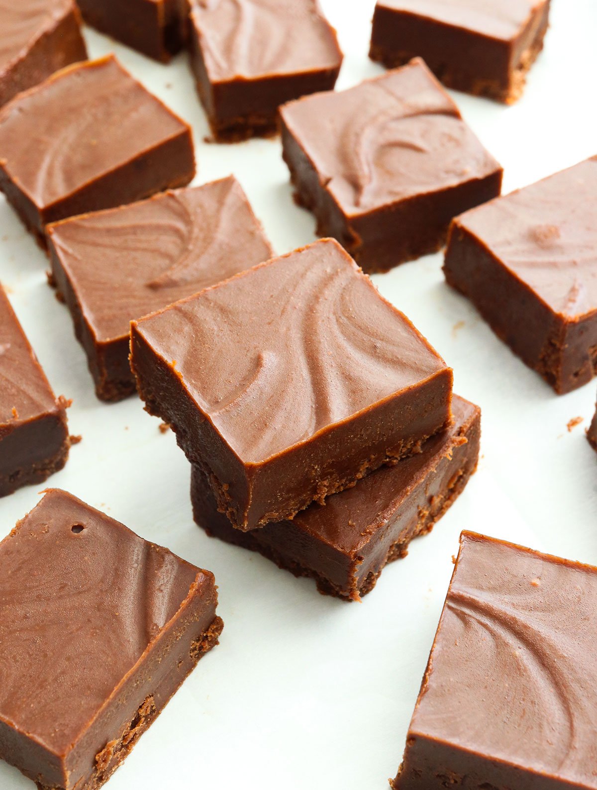 vegan fudge cut on white parchment paper and stacked.